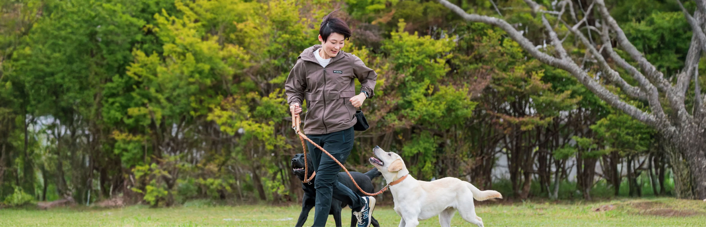 DOG JOURNEY代表の篠原 真歩様と愛犬が屋外で触れ合うメインビジュアル