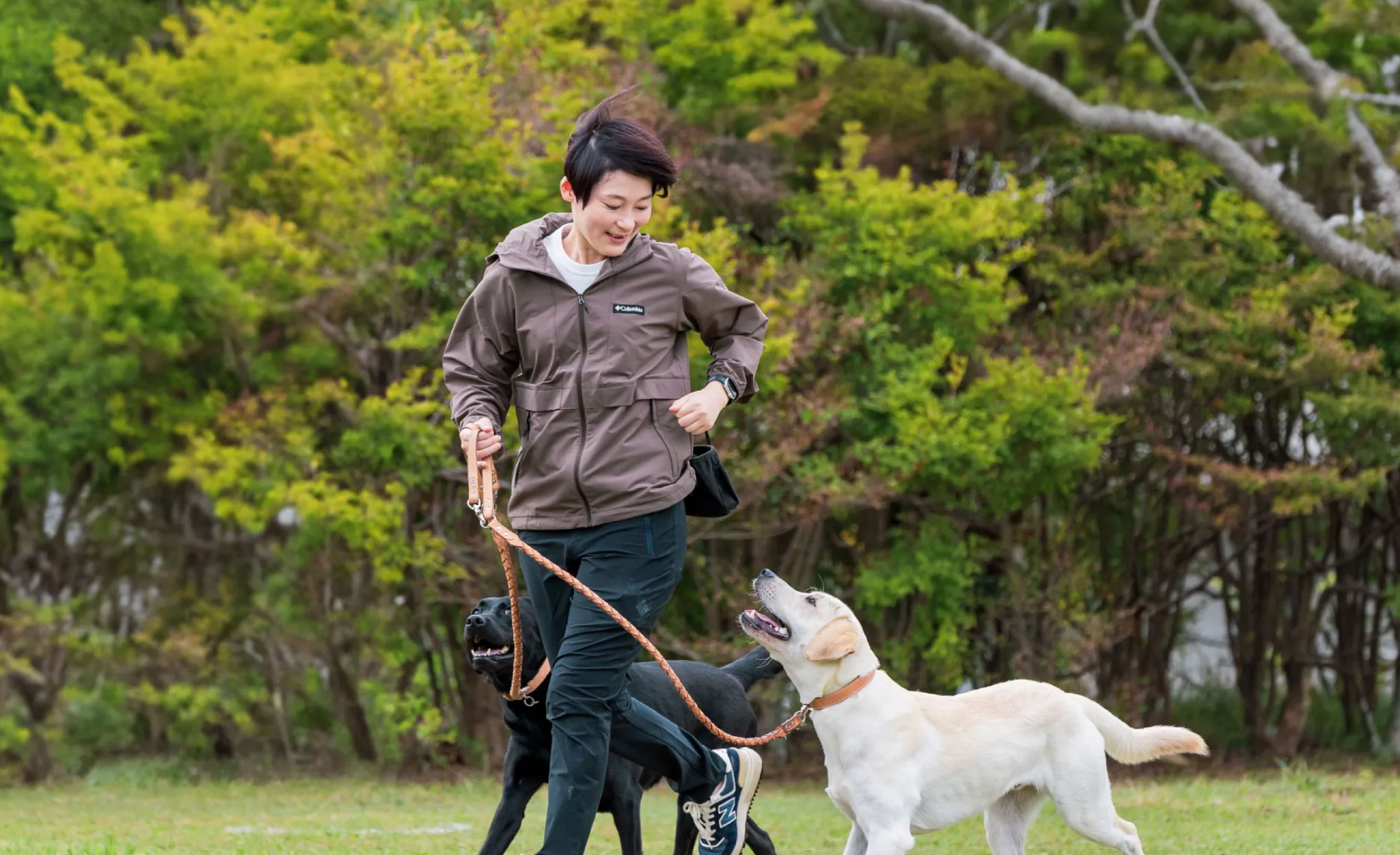 DOG JOURNEY代表の篠原 真歩様と愛犬が屋外で触れ合うメインビジュアル